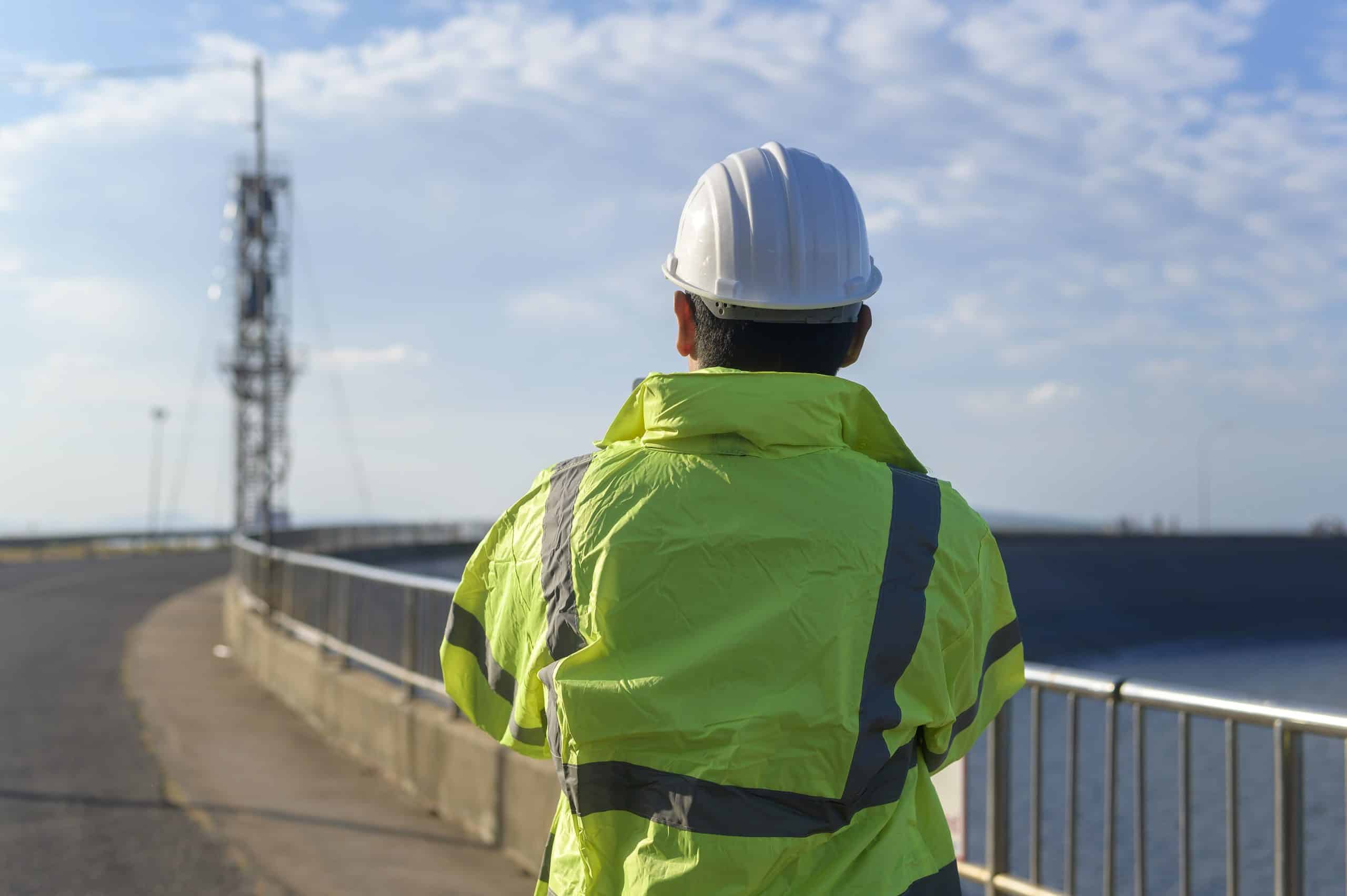 a man wearing a hard hat and yellow jacket